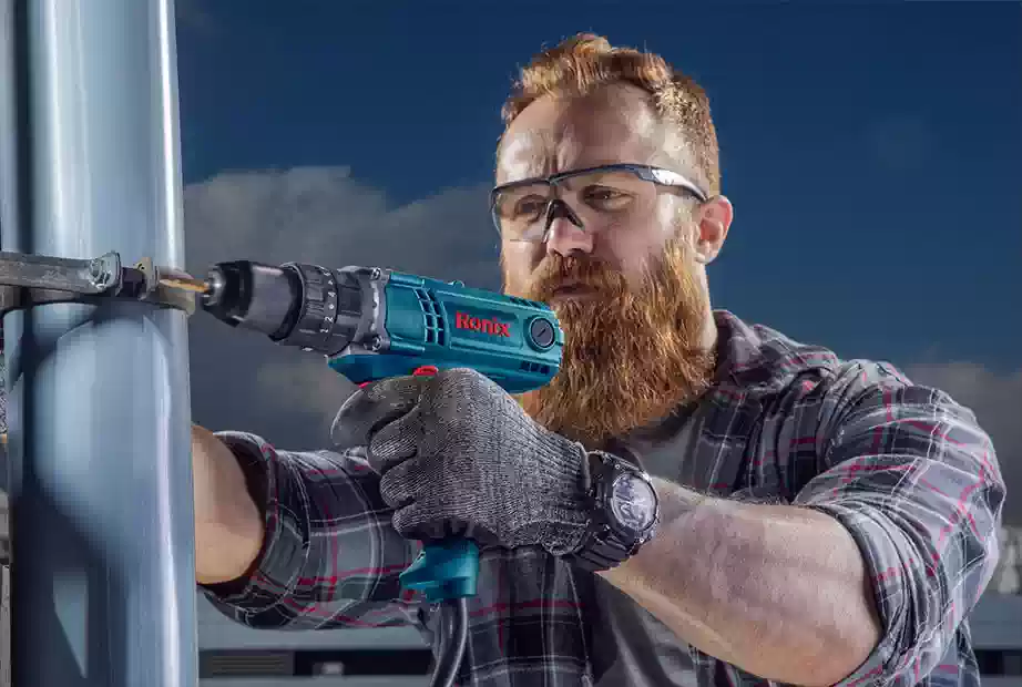 A man using an impact driver to loosen a screw