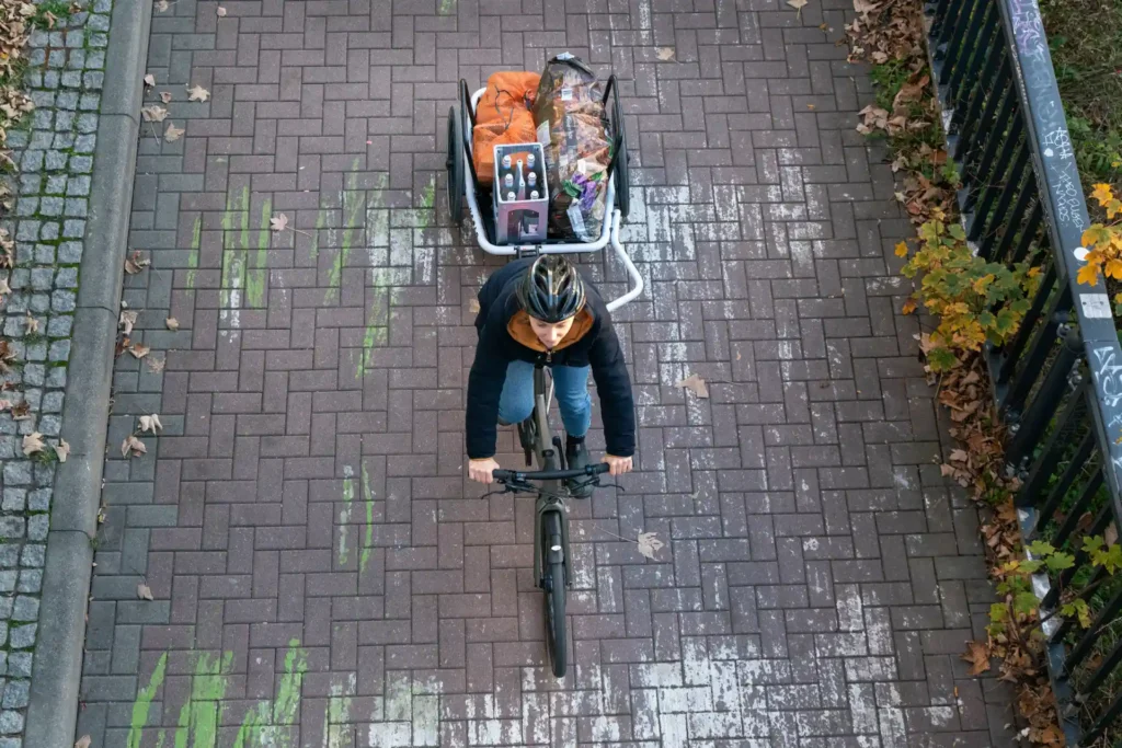 Fahrradfahrerin transportiert Einkauf mit Fahrradanhänger, fahrradanhänger schloss