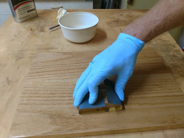 Wipe on poly being applied with block and sandpaper